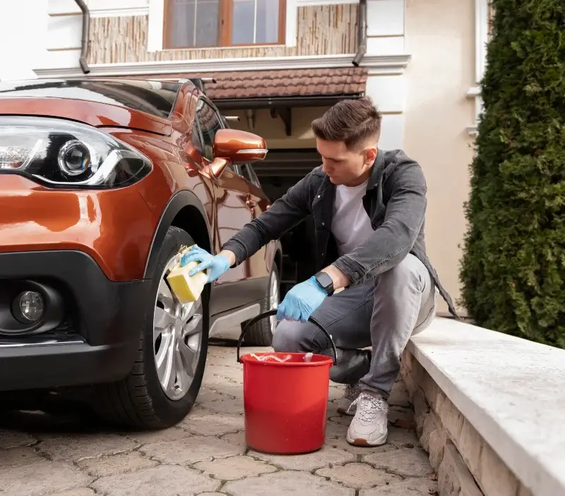Lavage auto à domicile Sainte-Eulalie-d'Olt : professionnel intervenant sur un véhicule